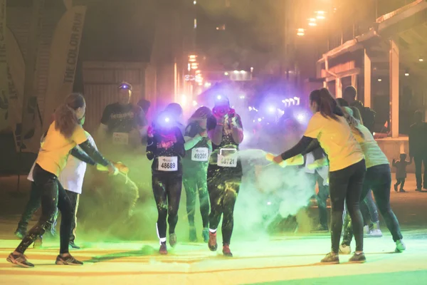 Colorful happy people at yellow station in the Color Run Night E — Stock Photo, Image