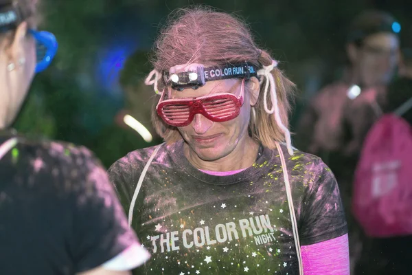 Friends with colorful glasses at the Color Run Night Edition in