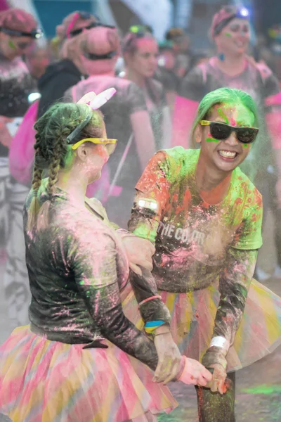 Amigos lanzando color el uno al otro en el Color Run Night Edit —  Fotos de Stock