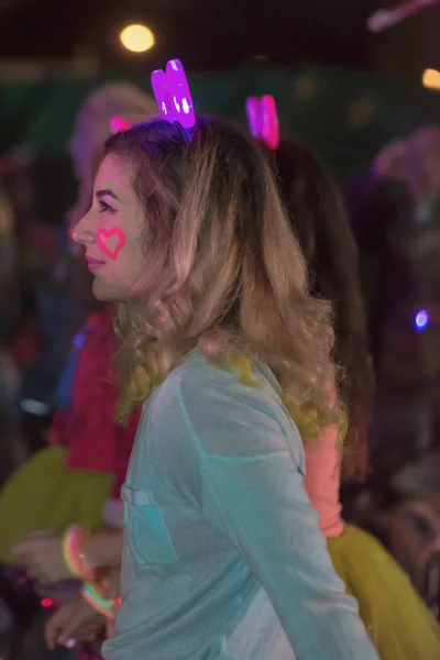 Colorful happy woman at the Color Run Night Edition in Stockholm