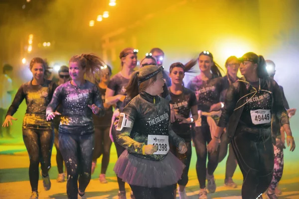 Colorful happy people at yellow station in the Color Run Night E — Stock Photo, Image