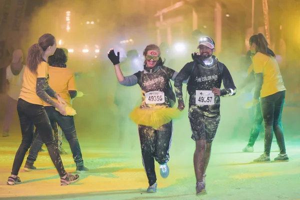 Kleurrijke gelukkige mensen op gele station in de Color Run nacht E — Stockfoto