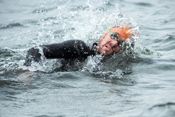 Närbild av en triathlet i mens simmar i kallt vatten en — Stockfoto