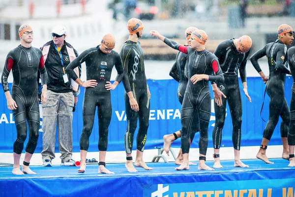 Triatletas discutindo antes do início nos homens nadando em — Fotografia de Stock