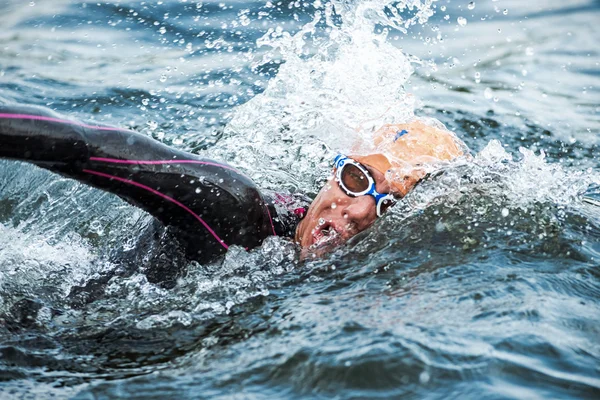 Närbild av en triathlet som simmar i kallt vatten på kvinnans — Stockfoto