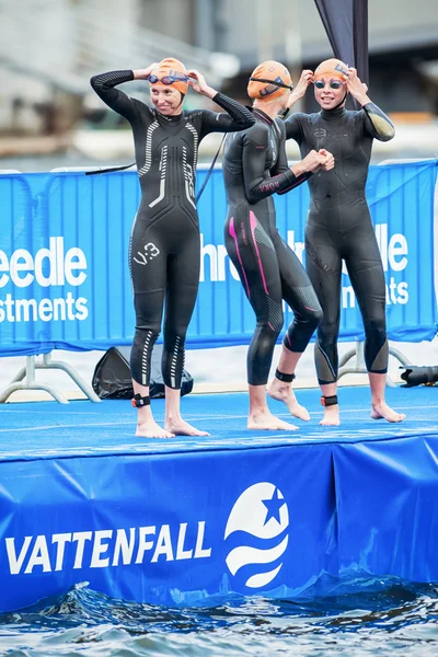 Des triathlètes heureuses se préparent devant les femmes nageant dans le froid — Photo