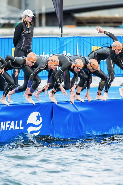 Triathleten beginnen in de womens in het koude water bij zwemmen — Stockfoto