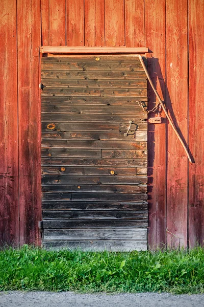 Old weathered black barn door with locks and shingles — Stock Photo, Image