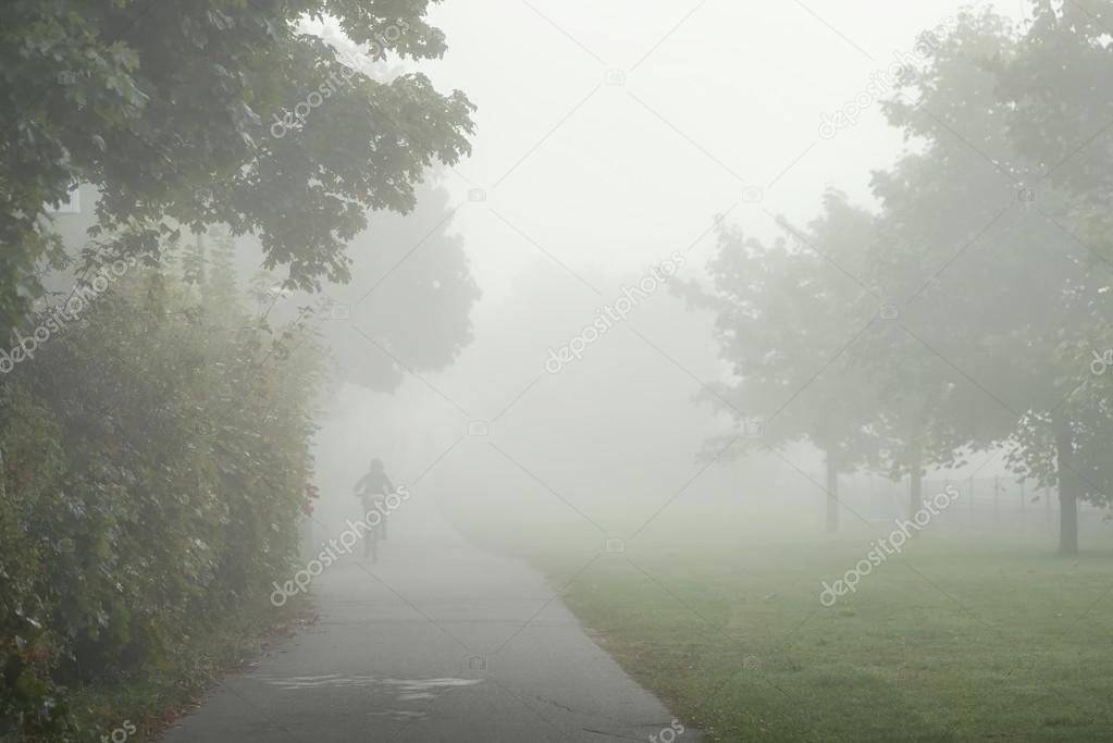 Cyclist during a very misty morning