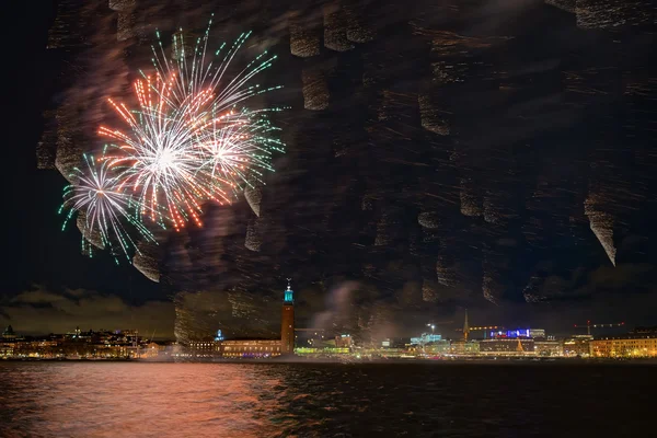 Fogos de artifício sobre o céu noturno de Estocolmo com reflexos na água — Fotografia de Stock