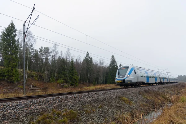 Banliyö treni geliyor bir eğri manzarada — Stok fotoğraf