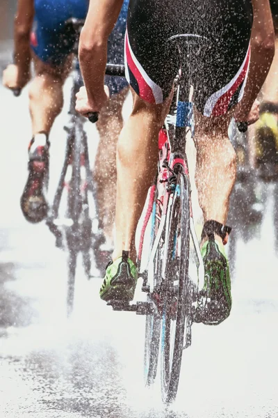 Bisikletçiler tekerlekler püskürtme su ile şiddetli yağmur