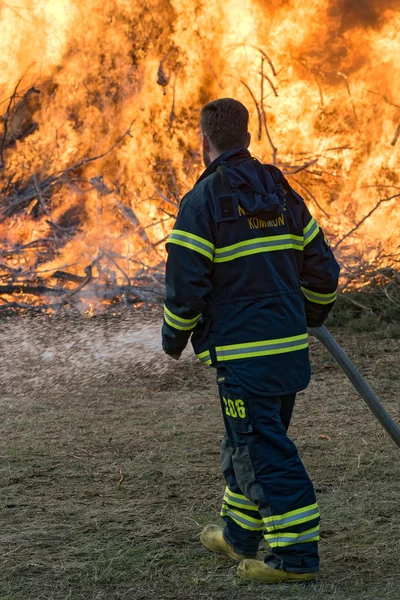 Firefighter tending to a controlled Walpurgis fire — Stock Photo, Image