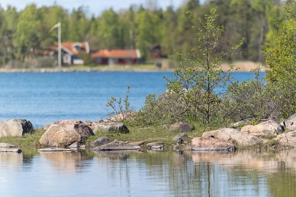 Маленький остров у озера с деревьями и красными домиками в баке — стоковое фото