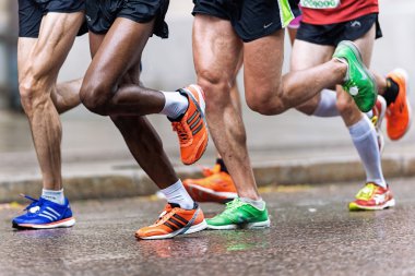 Grup koşucu renkli Ayakkabı ve kaslı bacaklarına asics ile 