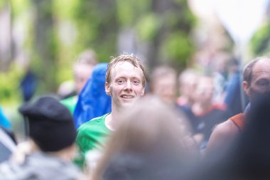asics stockholm maratho, yemyeşil bir alanda kalabalıkta mutlu adam