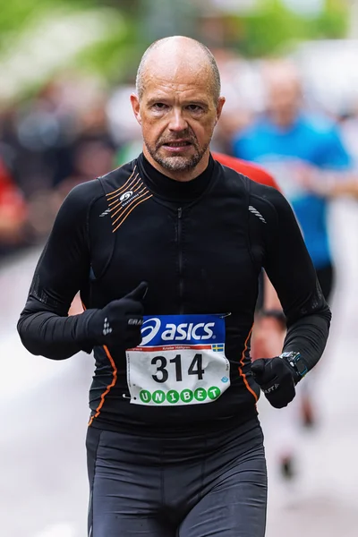 Determinded man in black in ASICS Stockholm Marathon — Stock Photo, Image