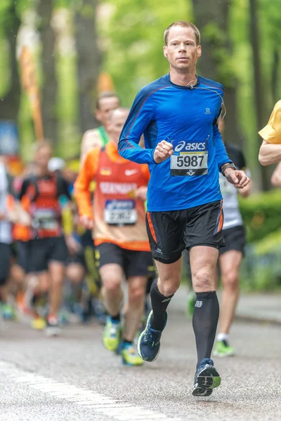 Running man in blue at a lush area at ASICS Stockholm Marathon — Stock Photo, Image