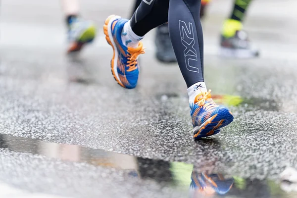 Sapatos de corrida coloridos com reflexos no asfalto molhado no AS — Fotografia de Stock