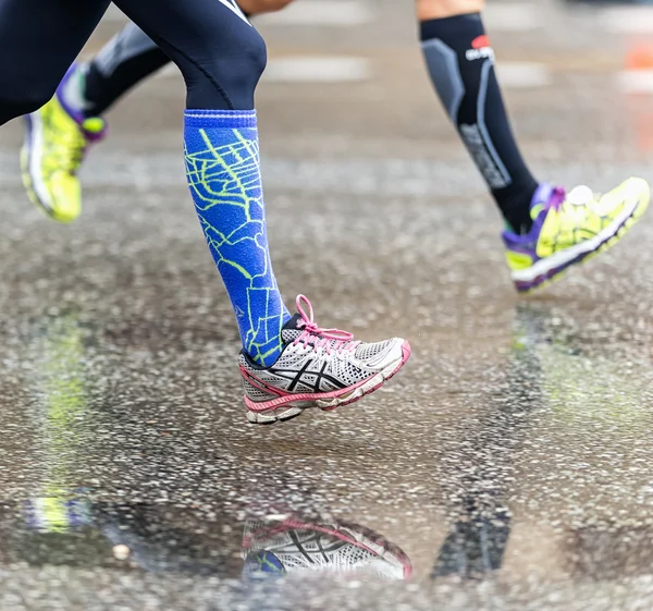Farbenfrohe Laufschuhe mit Spiegelungen im nassen Asphalt — Stockfoto