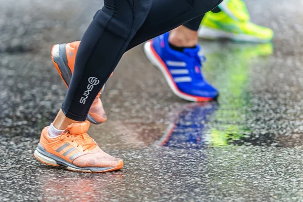 Koşu ayakkabıları ıslak Viyadükler, su birikintileri yansıtan renkli neon — Stok fotoğraf