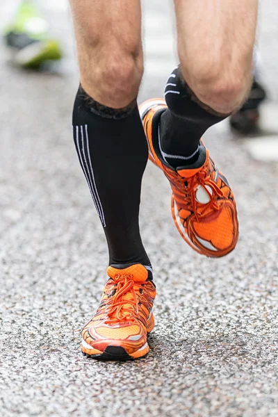 Gros plan des coureurs pieds et jambes en vue avant dans la rue humide — Photo