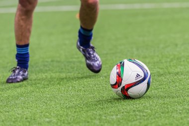 Soccer players legs and shoes aiming at the football during warm