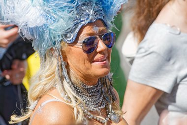 Happy smiling woman with feathers at the Pride parade