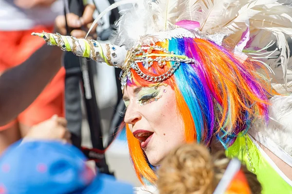 Person in rainbow hair and unicorn costume at the Pride parade — Stok fotoğraf