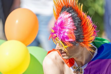 Man with a colorful wig in rainbow colors at the Pride parade