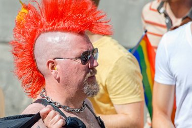 Man in profile with red mohikan at the Pride parade