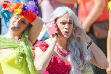 Crossdresser talking in the smartphone at the Pride parade