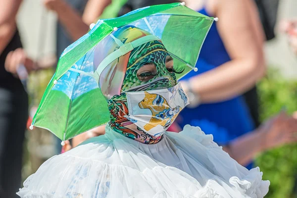 Persona con maschera colorata e ombrello come cappello al Pride p — Foto Stock