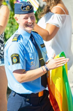 Happy woman police with rainbow flag in her hand at the Pride pa