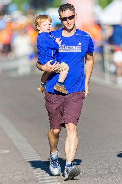 Dad assisting his son at the Minimil for the youngest runners at