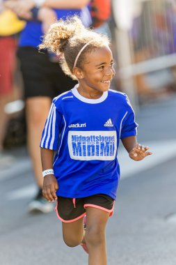 Smiling happy girl at last 50 meters at the Minimil for the youn