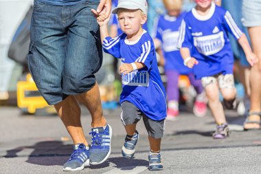 Young boy grabbing fathers finger at the Minimil for the younges
