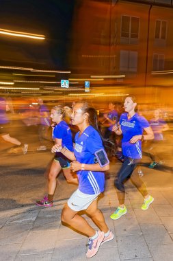 Closeup of female runner in colorful lights on the streets of So