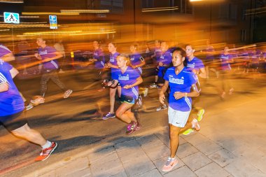 Female runners in colorful lights on the streets of Soder at Mid