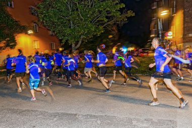 Group of runners in colorful lights on the streets of Soder at M