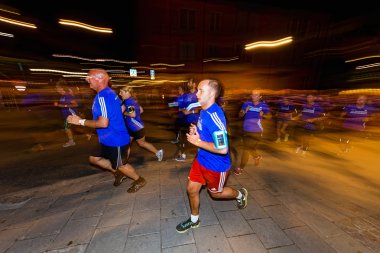 Group of runners in colorful lights on the streets of Soder at M