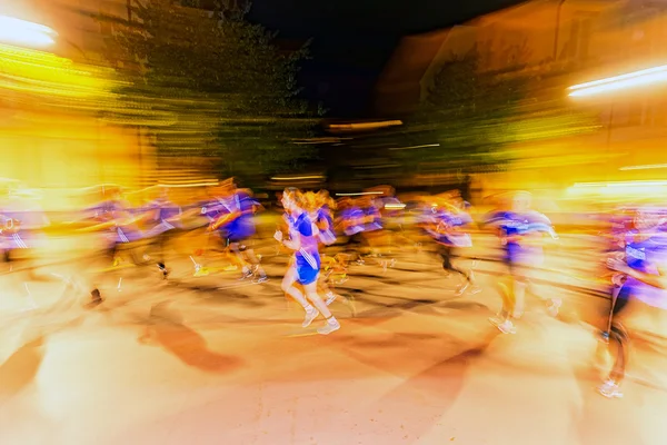 Runners in motion blur and colorful light trails on the streets 