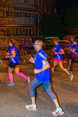 Male runner with motion blur on the streets of Soder at Midnatts