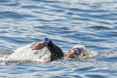 Face of a female triathlete swimming and gasping for air at Wome