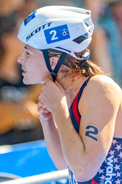 Sarah True into the transition for cycling putting helmet on at 