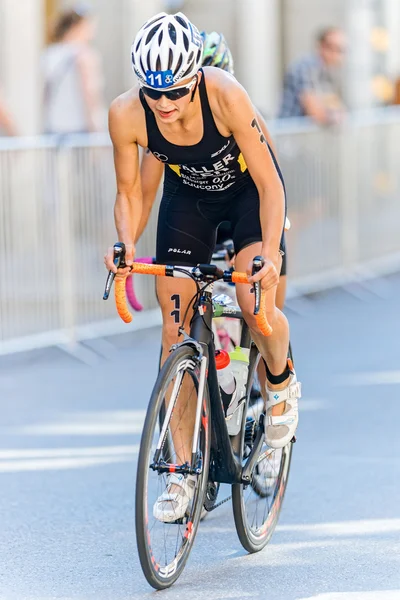 Triatleta Sophia Saller primer plano de ciclismo en el casco antiguo de la — Foto de Stock