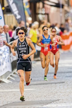 Yuko Takahashi (JPN) leading a group of runners at the cobblesto