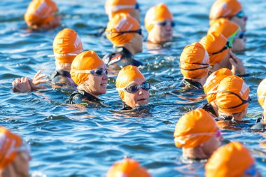 Triathletes in orange caps waiting for the start at the Womens I
