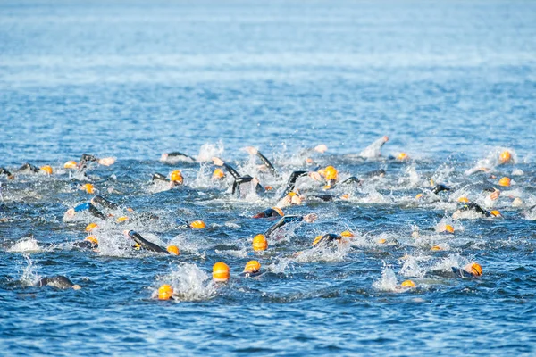 Field of woman triathletes with orange caps crawling at the Wome — Stock fotografie