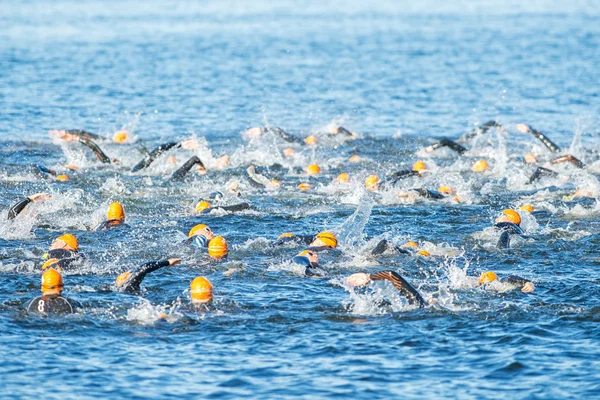 Field of woman triathletes with orange caps crawling at the Wome — Stockfoto
